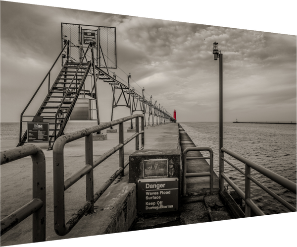 Gloomy black and white scene featuring Big Red on the Grand Haven Pier, showcasing a striking red lighthouse.