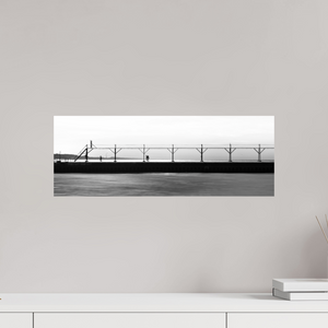 Couple strolls down The Pier in Black and White, with a bird flying by and smoke billowing from a distant smokestack.